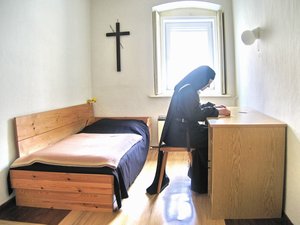English: A Discalced Carmelite nun sits in her...